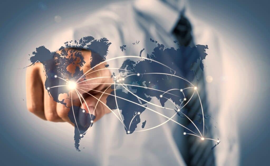 The image depicts a professional pointing to a digital world map interconnected with glowing lines, symbolizing the global reach and complexity of business and marketing. This visualization highlights the importance of understanding Regulations Guiding International Marketing, as businesses expanding their presence must navigate diverse legal landscapes while adhering to marketing compliance and cultural nuances in different regions.